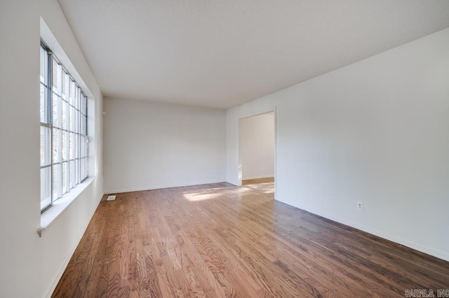 empty room with hardwood / wood-style flooring