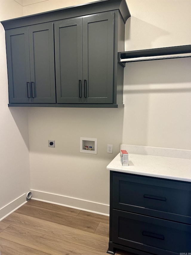 washroom featuring cabinets, washer hookup, light hardwood / wood-style flooring, and hookup for an electric dryer