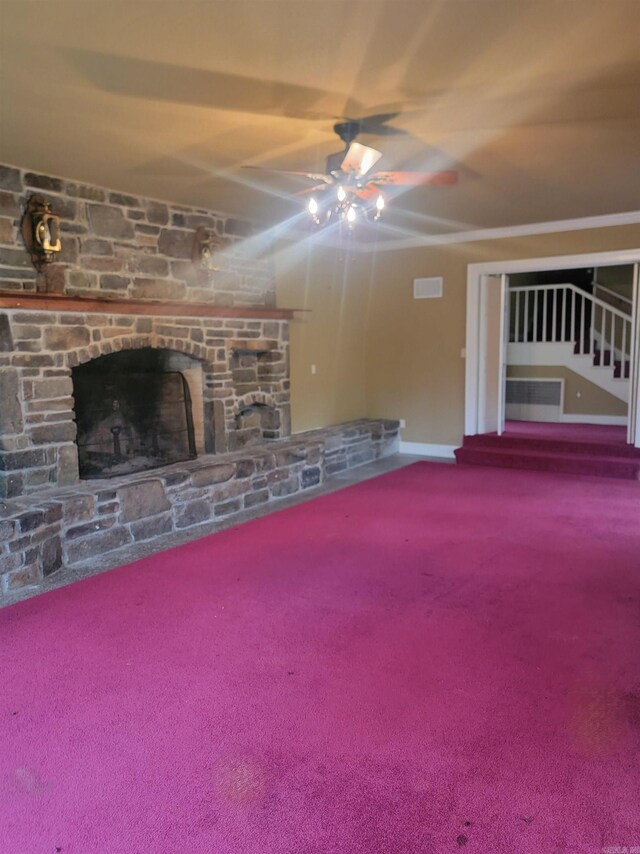 unfurnished living room featuring ceiling fan, carpet flooring, and a stone fireplace