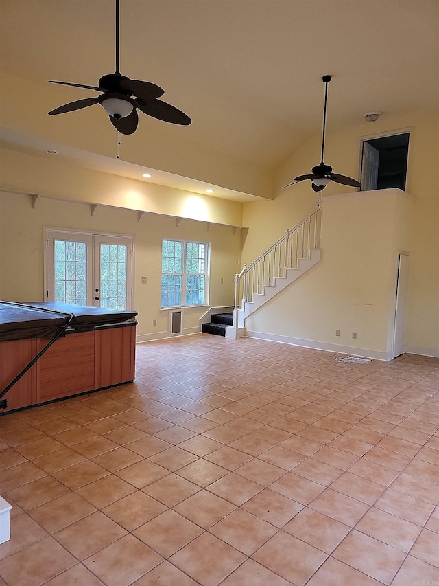 unfurnished living room with ceiling fan, light tile patterned floors, lofted ceiling, and french doors