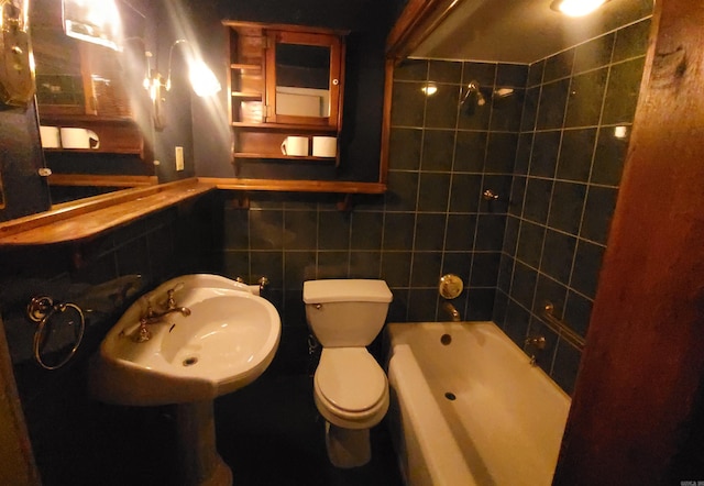 full bathroom featuring sink, tile walls, toilet, and tiled shower / bath