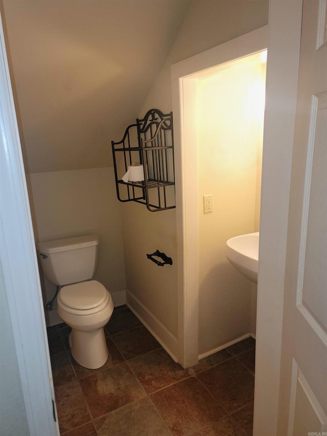 bathroom with toilet and vaulted ceiling