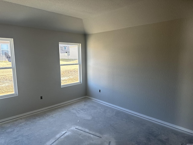 spare room with concrete floors and a textured ceiling