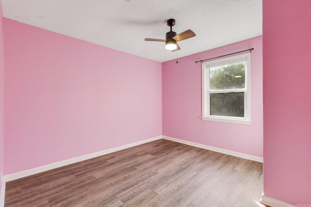 empty room featuring a textured ceiling, light hardwood / wood-style floors, and ceiling fan