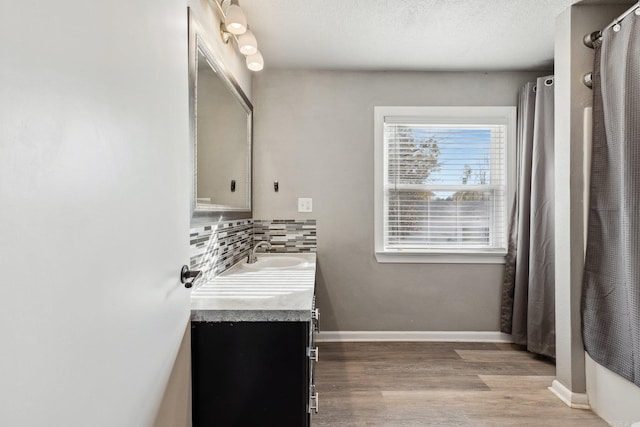 bathroom with decorative backsplash, a textured ceiling, vanity, and hardwood / wood-style flooring