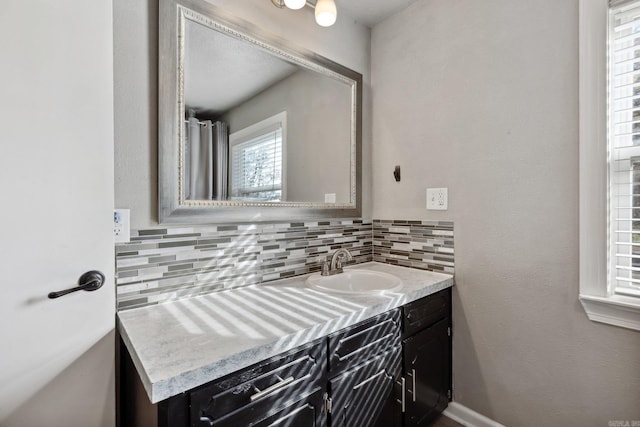 bathroom with vanity and tasteful backsplash