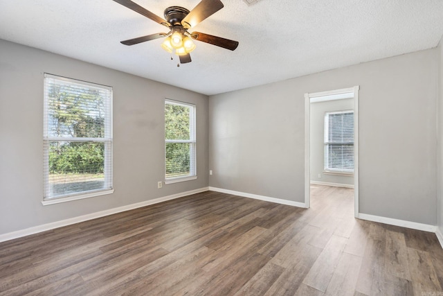 empty room featuring a textured ceiling, ceiling fan, and dark hardwood / wood-style floors