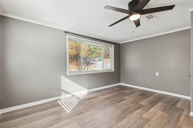 empty room featuring ceiling fan, wood-type flooring, a textured ceiling, and ornamental molding
