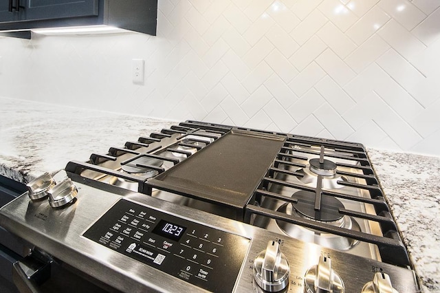 interior details with light stone countertops and appliances with stainless steel finishes