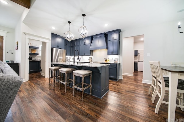 kitchen with a center island with sink, a breakfast bar, dark hardwood / wood-style flooring, and custom range hood