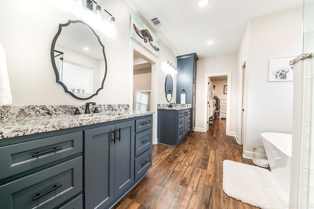 bathroom featuring vanity, hardwood / wood-style flooring, and a bathtub