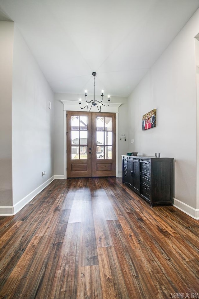 interior space with french doors, dark wood-type flooring, and a notable chandelier