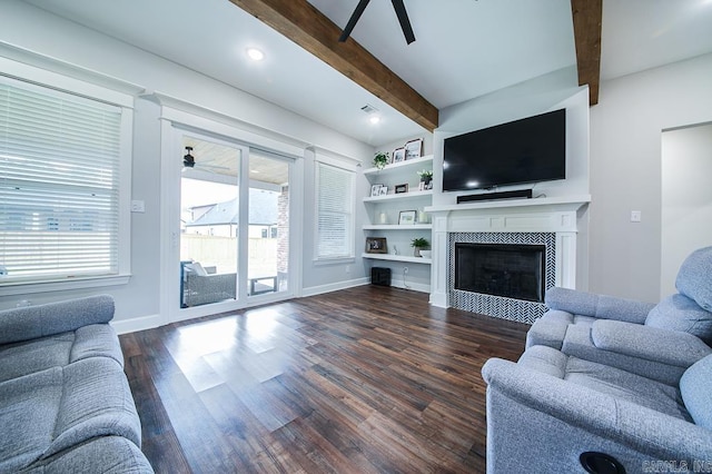 living room with beam ceiling, a tiled fireplace, ceiling fan, and dark hardwood / wood-style flooring