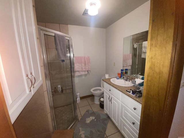 bathroom featuring tile patterned flooring, vanity, toilet, and a shower with shower door