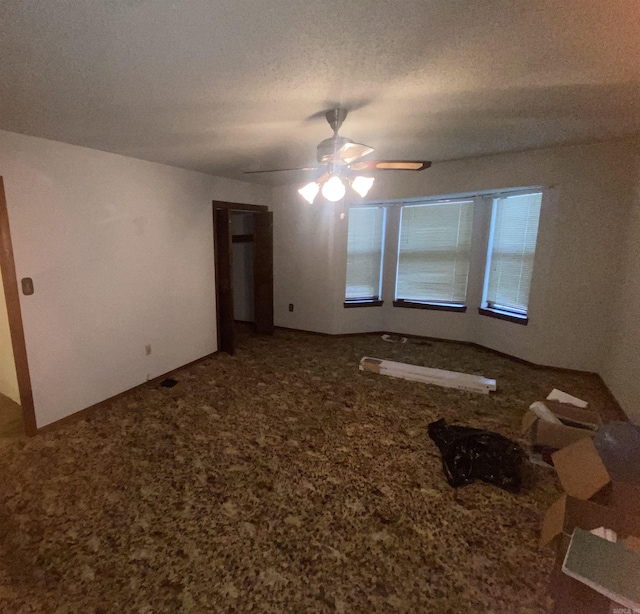 unfurnished room featuring carpet flooring, ceiling fan, and a textured ceiling