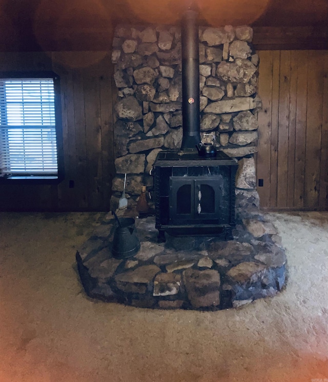 interior details featuring a wood stove and wood walls