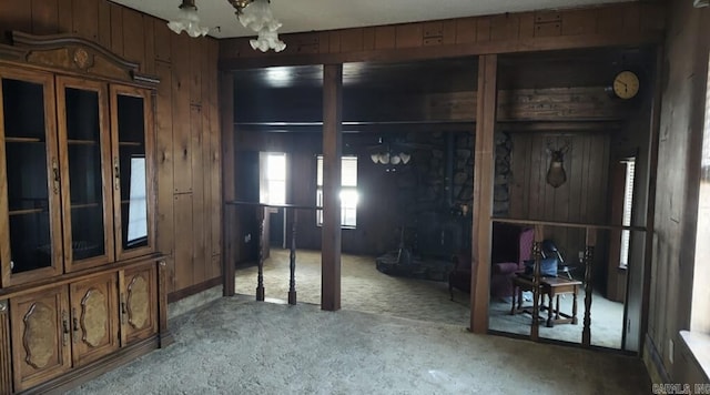 misc room featuring wood walls and an inviting chandelier