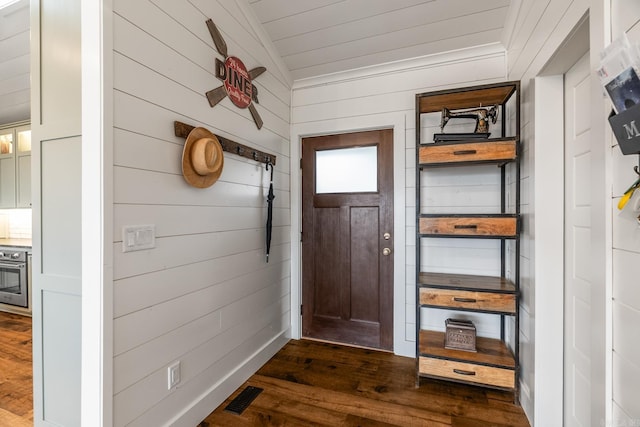 mudroom featuring wooden walls, dark hardwood / wood-style flooring, and vaulted ceiling