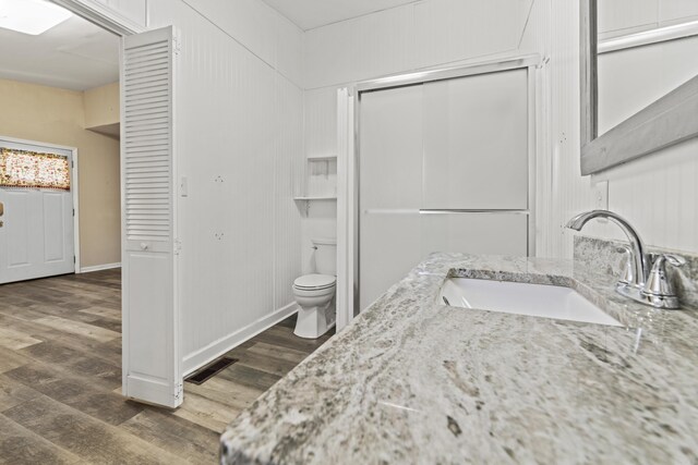 bathroom with hardwood / wood-style floors, vanity, and toilet