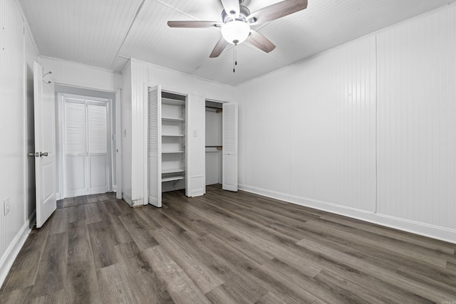 unfurnished bedroom featuring multiple closets, ceiling fan, and dark hardwood / wood-style floors