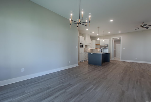 kitchen featuring white cabinetry, a kitchen island with sink, hanging light fixtures, and wood-type flooring