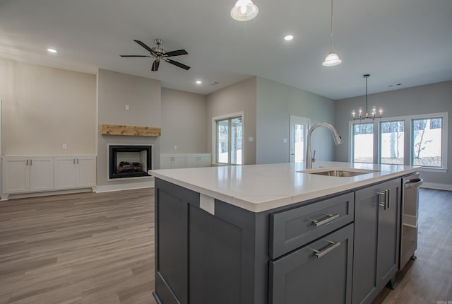 kitchen with pendant lighting, a kitchen island with sink, a healthy amount of sunlight, and sink