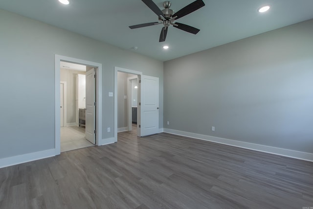 unfurnished bedroom featuring hardwood / wood-style flooring, ceiling fan, and ensuite bathroom