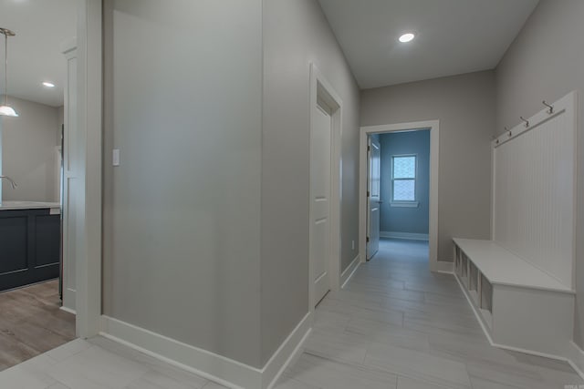 mudroom with light wood-type flooring and sink