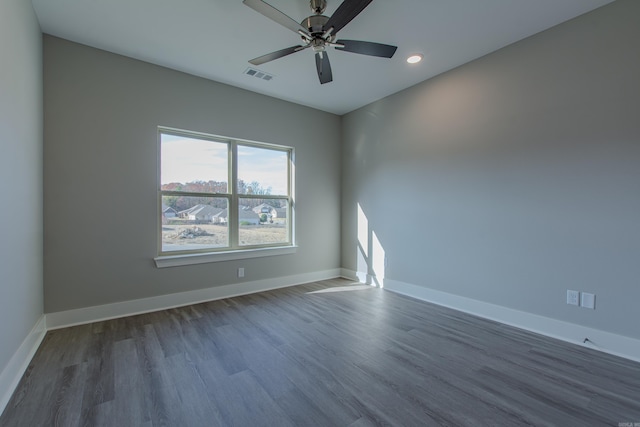 empty room featuring dark hardwood / wood-style flooring and ceiling fan