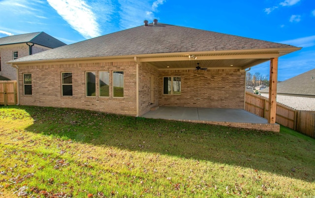 rear view of property featuring a lawn, ceiling fan, and a patio area