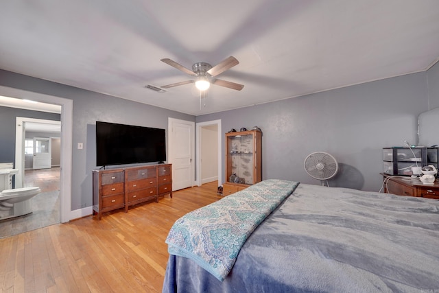 bedroom featuring ceiling fan, light wood-type flooring, and ensuite bath