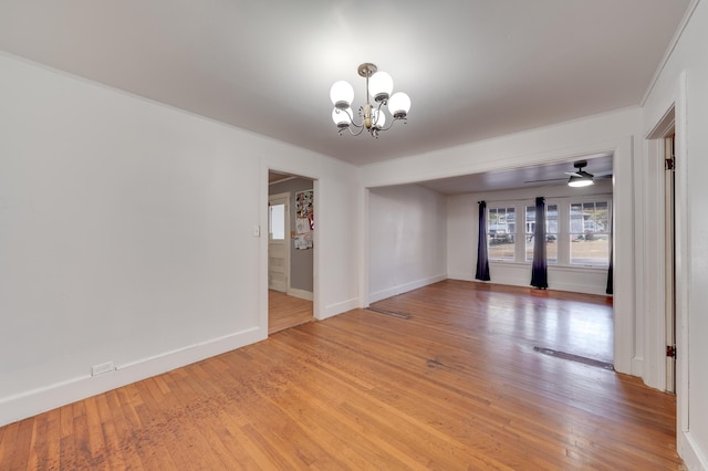 unfurnished room featuring hardwood / wood-style flooring, ceiling fan with notable chandelier, and crown molding