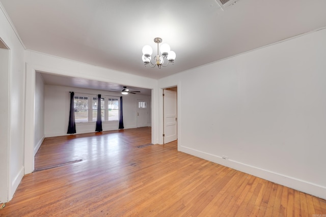 empty room with ceiling fan with notable chandelier and light wood-type flooring