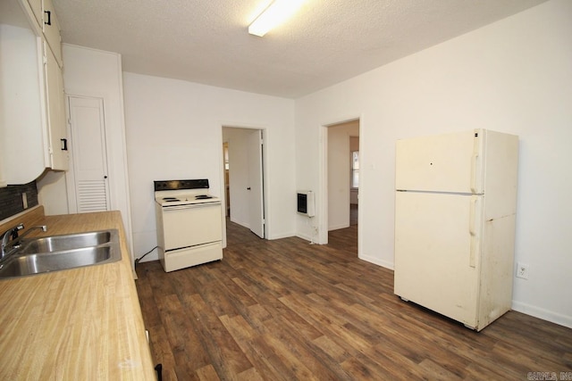 kitchen with white appliances, sink, a textured ceiling, dark hardwood / wood-style flooring, and heating unit