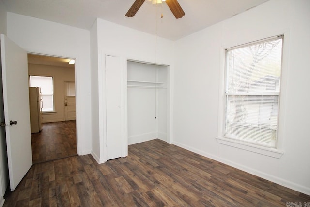 unfurnished bedroom with a closet, ceiling fan, dark hardwood / wood-style flooring, and white refrigerator