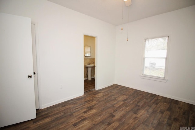 unfurnished room with ceiling fan, dark wood-type flooring, and sink