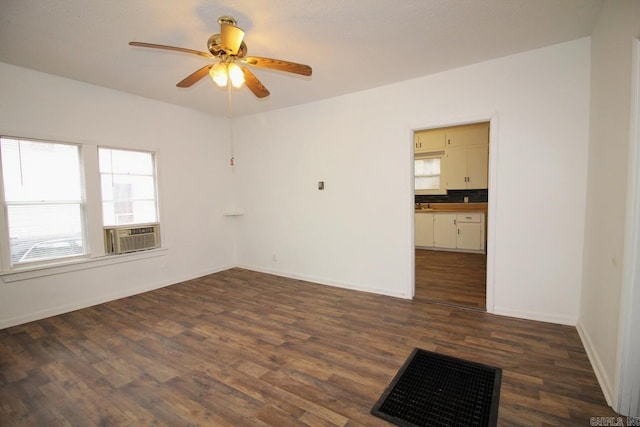 empty room with ceiling fan, dark hardwood / wood-style flooring, and cooling unit