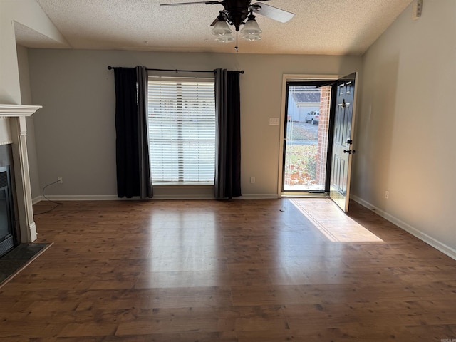 unfurnished living room with lofted ceiling, a textured ceiling, ceiling fan, and dark wood-type flooring