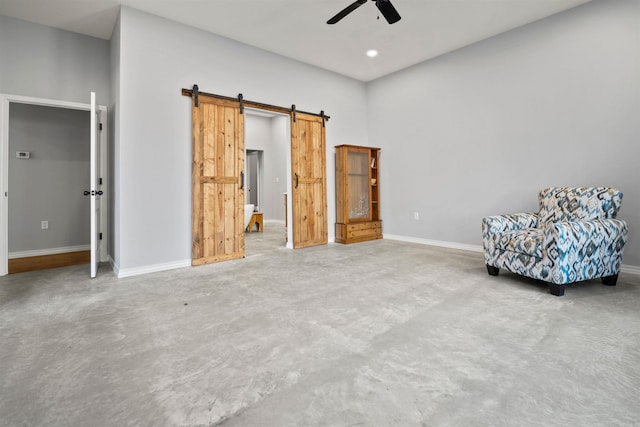 unfurnished room with a barn door and ceiling fan