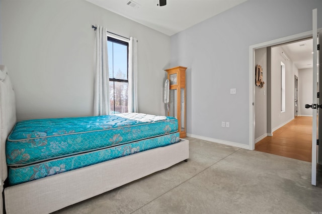 bedroom with ceiling fan and concrete flooring