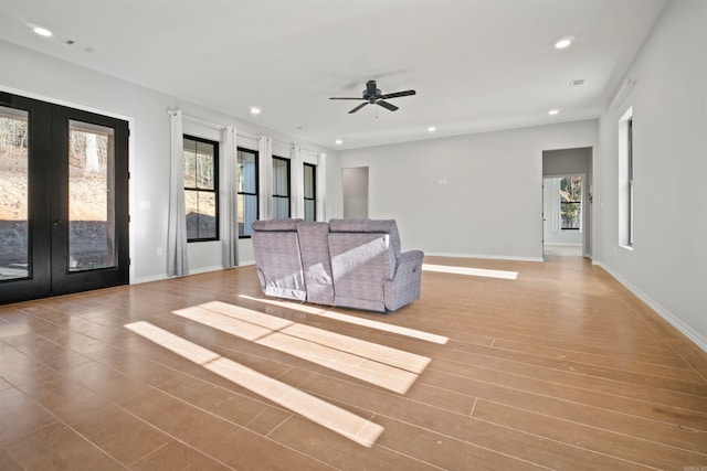 unfurnished living room featuring french doors, light hardwood / wood-style floors, and ceiling fan