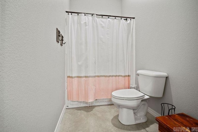 bathroom featuring shower / bath combo and toilet