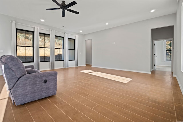 living room featuring wood-type flooring and ceiling fan