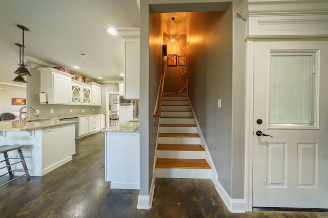 staircase featuring concrete floors and crown molding