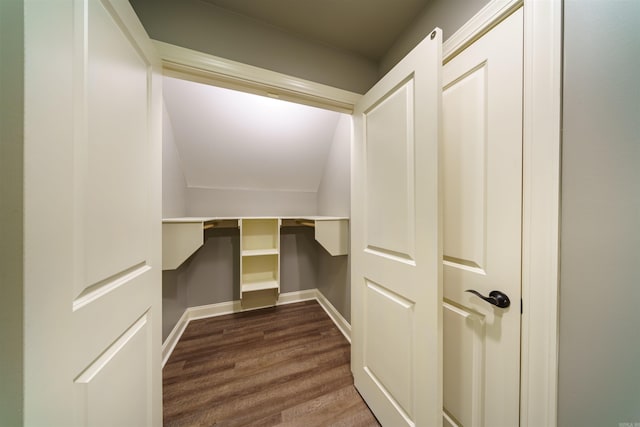 walk in closet featuring vaulted ceiling and dark hardwood / wood-style floors