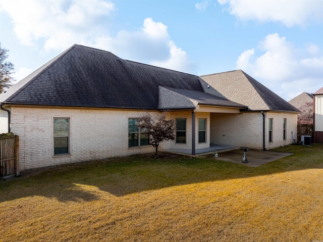 rear view of house featuring central AC unit, a patio area, and a yard