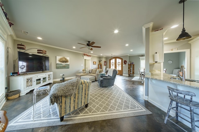 living room with ceiling fan, sink, and ornamental molding