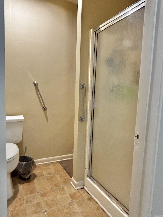 bathroom with toilet and an enclosed shower