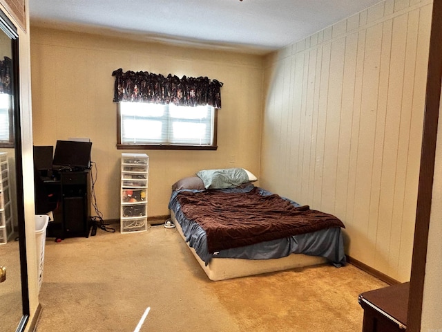 bedroom featuring wooden walls and carpet