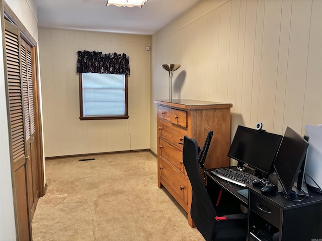 carpeted home office with wood walls